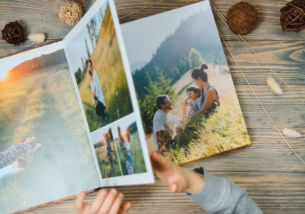 child-holding-family-photo-album-wooden-table